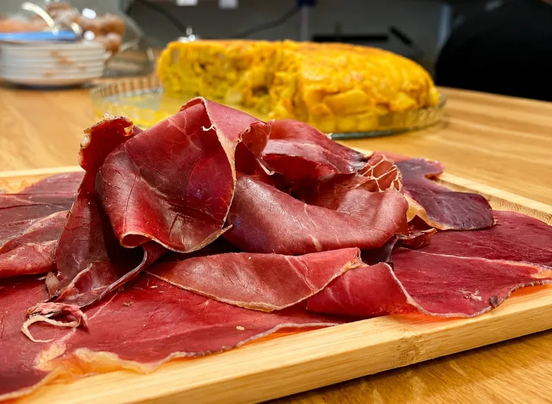 Cecina cortada junto a conservas y vinos gallegos